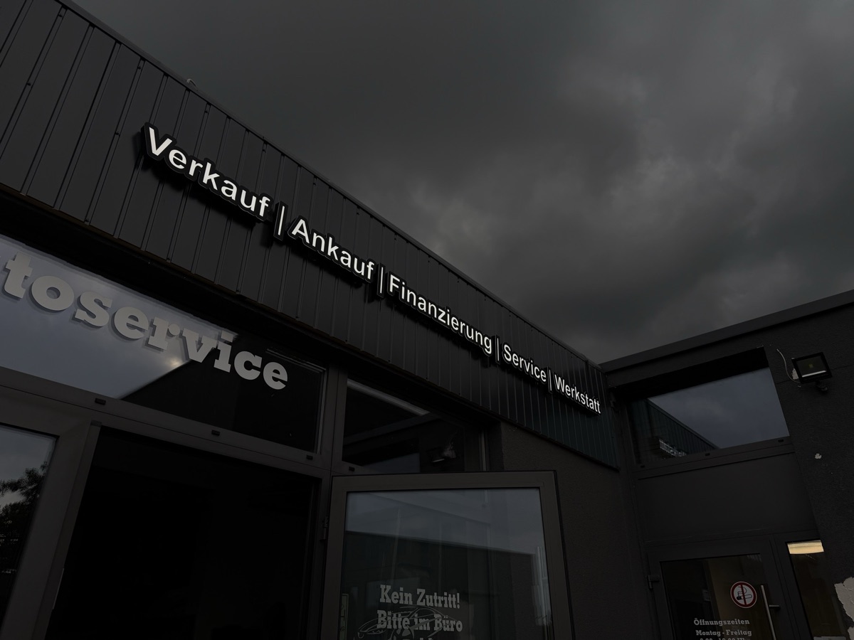 Verkauf, Ankauf, Finanzierung, Service, Werkstatt: weiße LED-Buchstaben an dunkler Fassade
